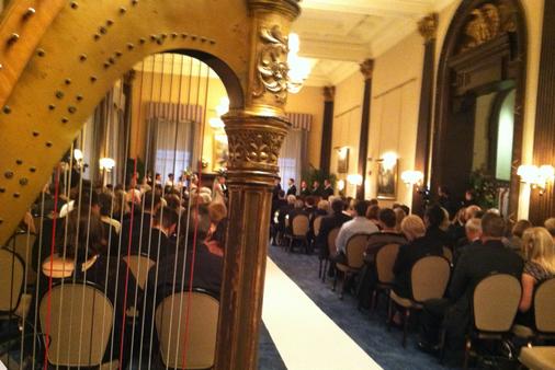 Harp in foreground at elegant wedding ceremony