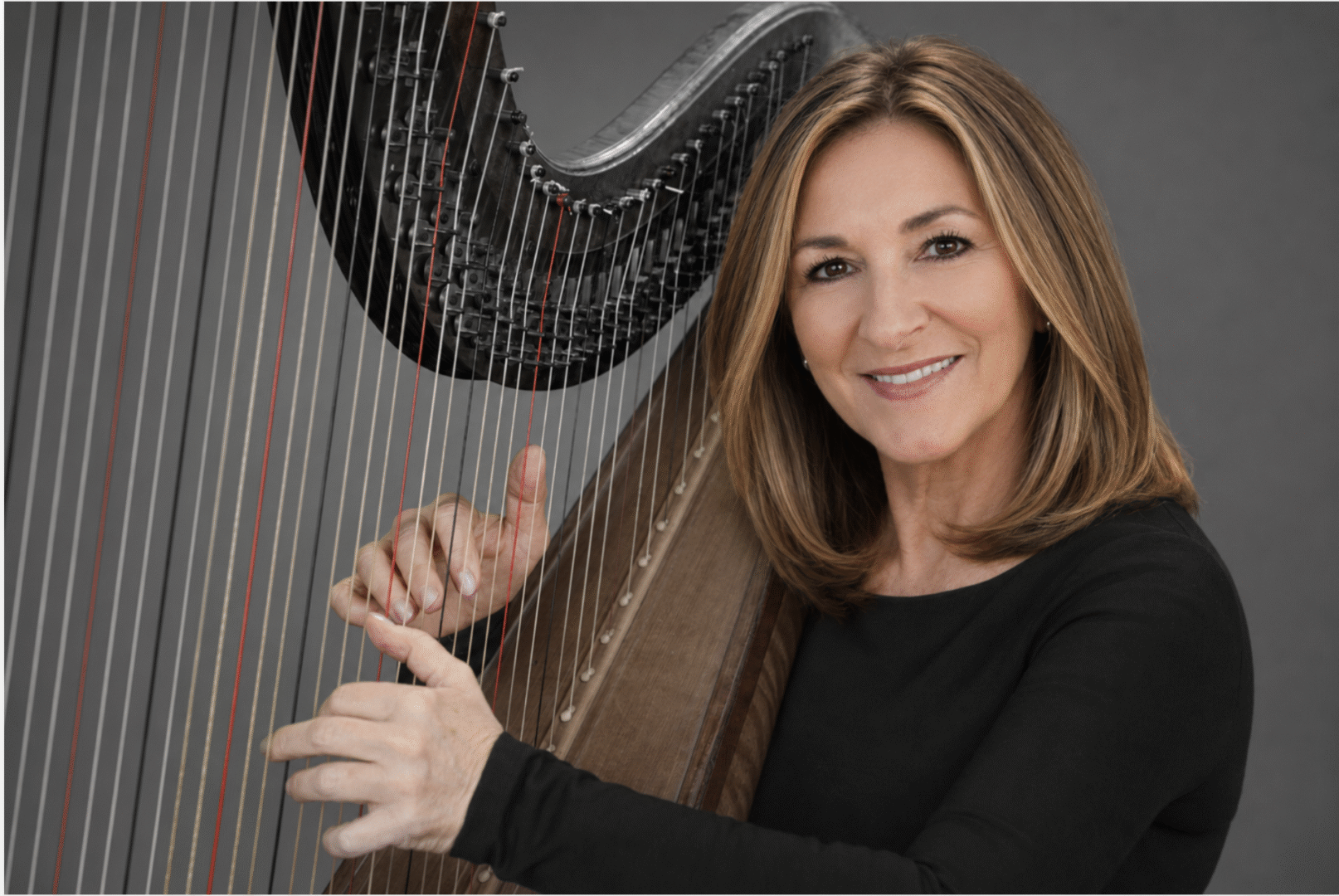 Woman smiling while playing a harp